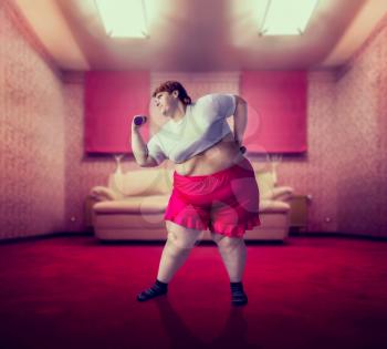 Fat woman on training with dumbbells, fight against obesity, overweight problem. Fastfood eating