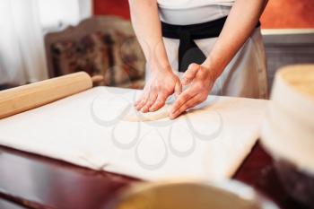 Male chef hands and dough on wooden table. Homemade strudel cooking