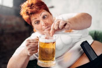 Overweight woman drinks beer and eats sandwich, bulimic, obesity. Unhealthy lifestyle, fatty female