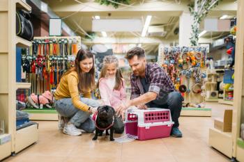 Family buying supplies for little puppy in petshop. Father, mother and dauther chooses accessories for dog in pet shop