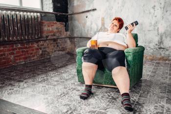 Overweight woman sitting in chair and drinks beer, high calorie food, obesity. Unhealthy lifestyle, fatty female