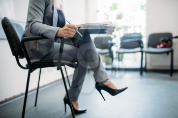 Woman in suit passes interview in business office. Secretary or manager conducts negotiations sitting on a chair. Job search or head hunting concept