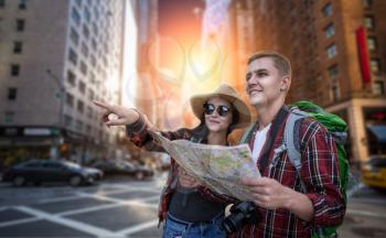 Travelers with backpacks looking for city attractions on the map, excursion in tourist town. Summer hiking. Hike adventure of young man and woman