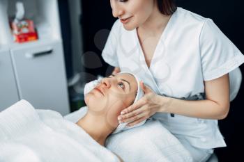 Face massage to female patient, cosmetology clinic. Facial skincare, rejuvenation procedure in spa salon