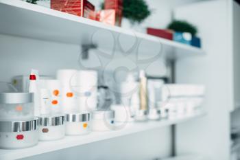 Shelf with creams, rejuvenation cosmetic in cosmetology clinic, nobody. Professional skincare products