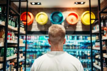 Male customer choosing drinks in supermarket. Shopping in food store