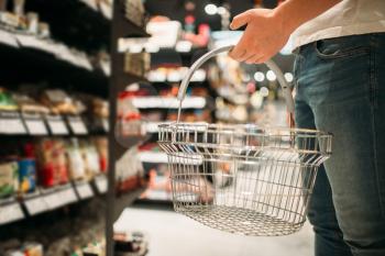 Male customer with empty basket in supermarket. Shopping in food store or in grocery