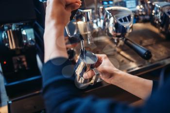 Male barista prepares beverage on coffee machine in cafe. Professional espresso preparation by barman
