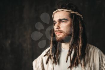 Portrait of man in the image of Jesus Christ, dark background. Christian faith, son of God