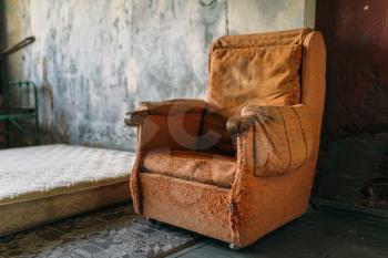 Drug addict room, grunge armchair and mattress on the floor in abandoned house, nobody. Junkie place, junky den, druggy stash