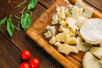 Cheese, oil and herb on wooden table closeup, top view, nobody. Garnish for meat, food preparation, cooking