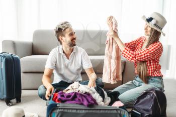 Man and woman packing their suitcases for vacation. Fees on journey concept. Luggage preparation
