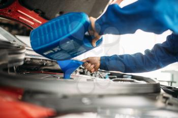 Technician change oil in the car engine. Vehicle motor maintenance, auto-service