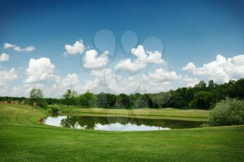 Mirror lake, trimmed lawn and sand bunkers for golfing on golf course, nobody. Meadow in sport club, playground landscape