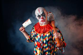 Mad bloody clown with meat cleaver and baseball bat, circus horror. Man with makeup in carnival costume, crazy maniac