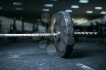Barbell on the floor in gym closeup view, nobody. Weightlifting sport concept, heavy weights