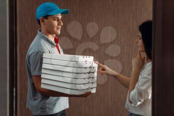 Female customer on the doorstep and pizza delivery boy, delivering service. Deliver from pizzeria and woman indoor