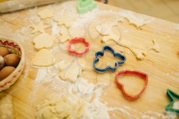 The dough cuted out by cookie cutters, nobody. Heart and gingerbread man pastry templates on the table