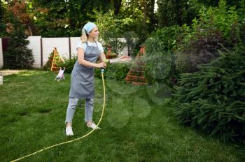 Woman with hose watering flowers in the garden. Female gardener takes care of plants outdoor, gardening hobby, florist lifestyle and leisure