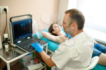 Male mammologist makes breast ultrasound scanning in clinic. Breast ultrasonography in hospital, professional diagnostic. Medical specialist and patient, mammography