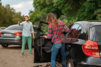 Male and female drivers after car accident on road. Automobile crash. Broken automobile or damaged vehicle, auto collision on highway