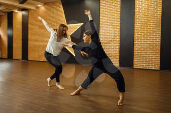 Two female contemporary dance performers poses in studio. Dancers training in class, modern elegance dancing, stretching exercise