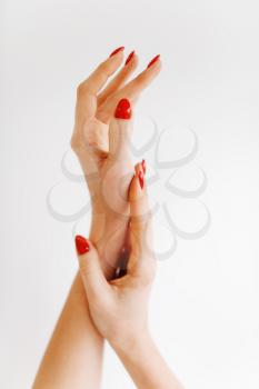 Beautiful female hands with red manicure isolated on white background. Beauty salon, professional service. Female customer hands after fingernail care procedure in spa studio