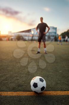 Soccer ball on line, player on the field on background. Footballer on outdoor stadium, workout before game, football training
