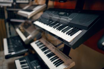 Digital synthesizers on showcase in music store, closeup view, nobody. Assortment in musical instrument shop, professional equipment for musicians and performers