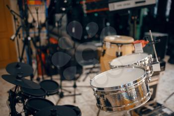 Drum set on showcase in music store, closeup view, nobody. Assortment in musical instrument shop, professional equipment for musicians and performers