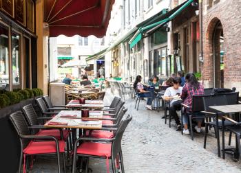 People in street cafe, old European tourist town. Summer tourism and travels, famous europe landmark, popular places for travelling