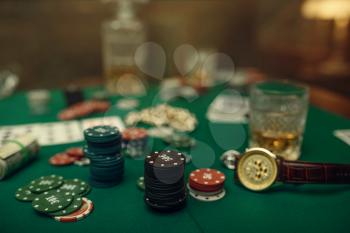 Poker concept, money bet, cards and chips on gaming table, whiskey and cigar in casino. Games of chance. Gambling house business