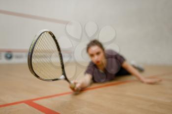 Female player with squash racket lies on the floor. Girl on game training, active sport hobby on court