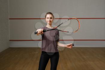 Female player shows squash racket on court. Girl on game training, active sport hobby, fit workout for healthy lifestyle
