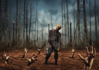 Male zombie in dried forest, scary monster came alive, fog on background. Horror, creepy crawlies attack, doomsday apocalypse