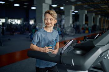 Boy doing exercise on treadmill in gym, running machine. Schoolboy on training, health care and healthy lifestyle