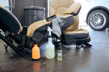 Leather car seats and tools for dry cleaning closeup, detailing. Vehicle washing in garage, thoroughly care of automobile, chemical and vacuum clean service