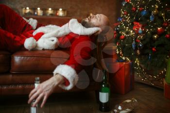Bad drunk Santa claus sleeps on sofa, hangover after nasty party, humor. Unhealthy lifestyle, bearded man in holiday costume, new year and alcoholism