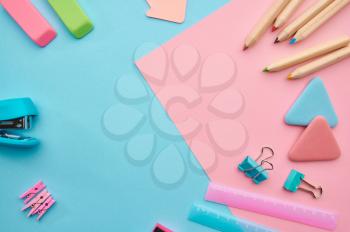 Office stationery supplies, blue and pink background. School or education accessories, writing and drawing tools, pencils and rubbers, ruler and paper clips