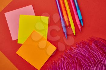 Pens and notepads closeup, red background. Office stationery supplies, school or education accessories, writing and drawing tools