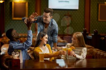 Four cheerful friends drinks alcohol at the counter in bar. Group of people relax in pub, night lifestyle, friendship, event celebration