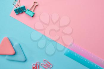 Paper clips and ruler closeup, blue and pink background. Office stationery supplies, school or education accessories, writing and drawing tools