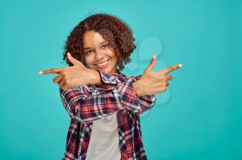 Young woman with crossed hands, blue background, positive emotion. Face expression, female person looking on camera in studio, emotional concept, feelings