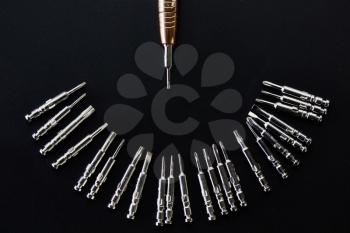 Screwdriver and set of replaceable bits, closeup, grey background, nobody. Professional instrument, worker equipment, screwing tools
