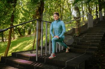Morning workout on stairs in park, sportive woman. Female runner goes in for sports at sunny day, healthy lifestyle, girl on outdoors training