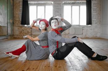 Male and female mime artists sitting on the floor, love couple parody scene, comedy. Pantomime theater, comedian, positive emotion, humour performance, funny face mimic and grimace