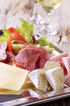 Slices of assorted cheeses, ham, and salami