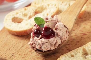 Liver pate on a wooden spoon and slices of bread