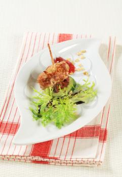 Meatball appetizer garnished with fresh endive and pine nuts