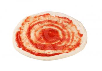 Tomato paste spread on raw pizza dough